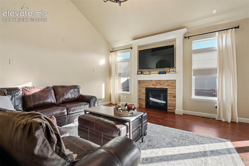 Image 6 of 47: Vaulted ceiling with a central lighting fixture, hardwood-finish flooring,
