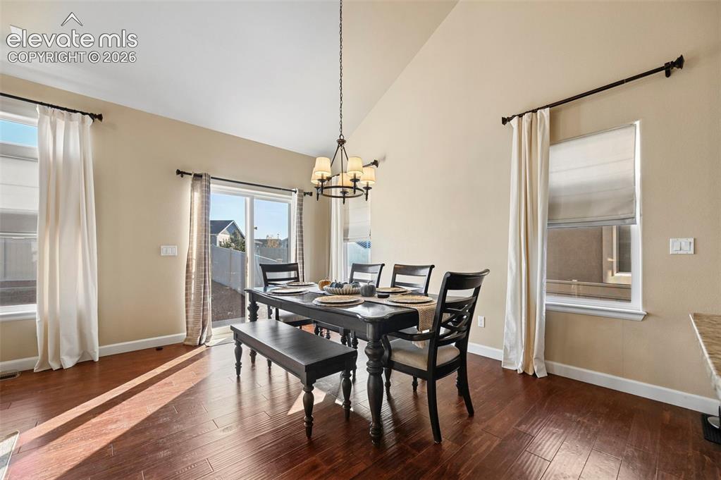 Image 8 of 47: Vaulted ceiling featuring a chandelier, wood-finish flooring, sliding glass