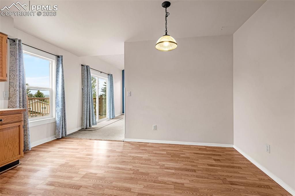 Image 10 of 41: Open-concept space featuring wood-finish flooring, a pendant light fixture,