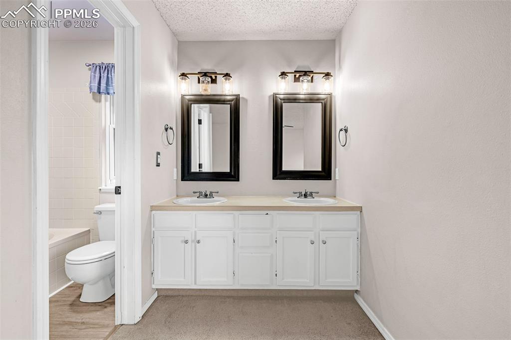 Image 14 of 41: Double vanity with white cabinetry and light-toned countertops