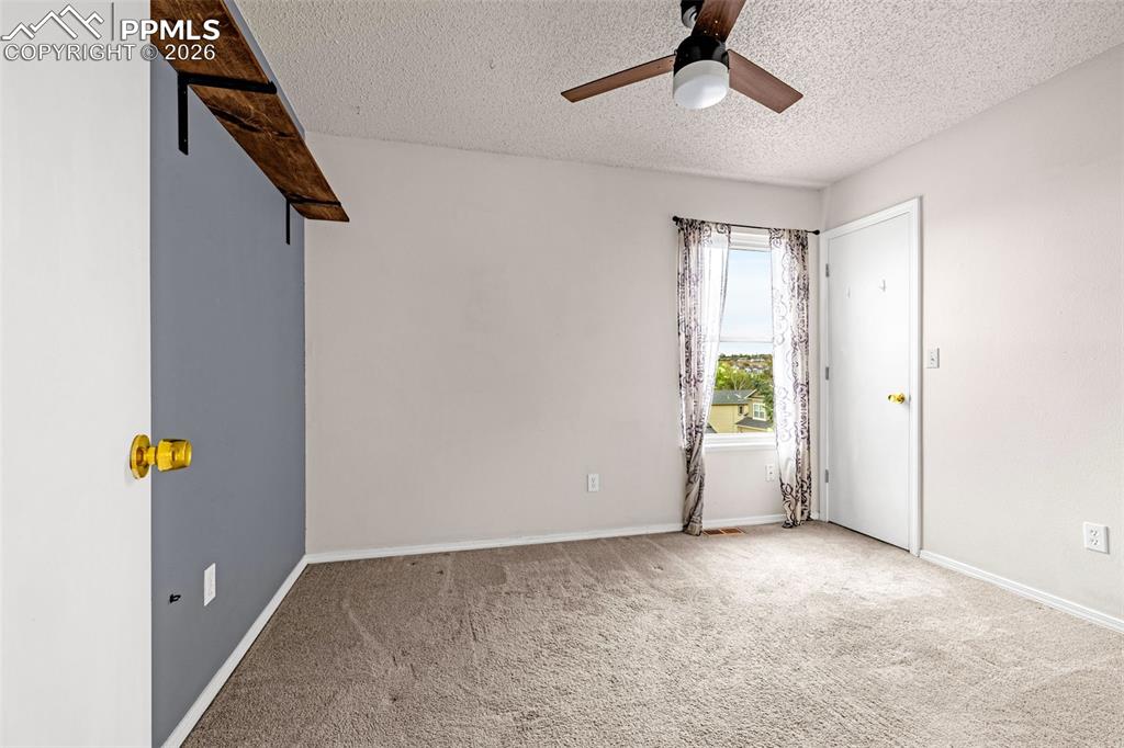 Image 16 of 41: Carpeted interior space featuring a window with patterned drapes, a ceiling