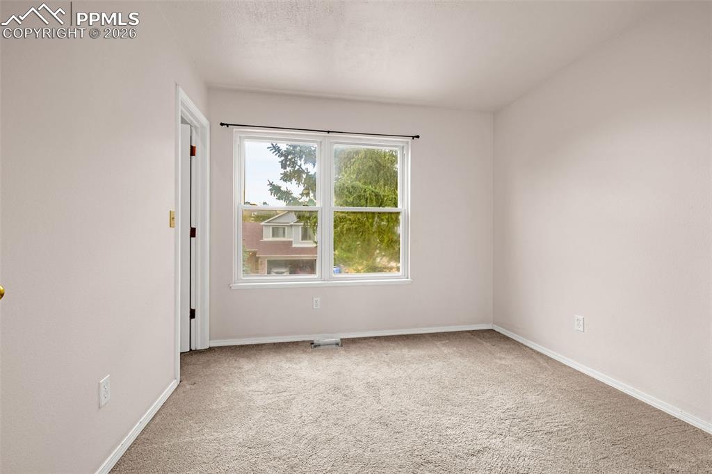 Image 17 of 41: Neutral-toned room featuring a large double window, light carpeting, and a 