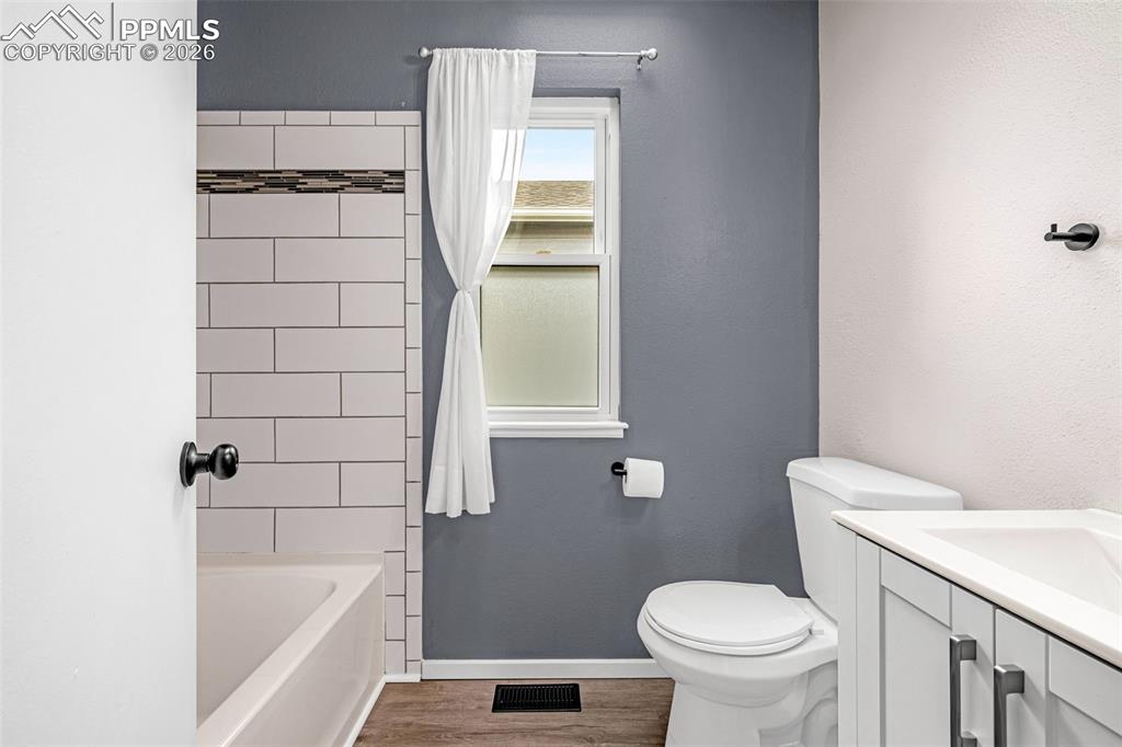 Image 18 of 41: Bathroom featuring a white subway tile shower surround with a decorative ac