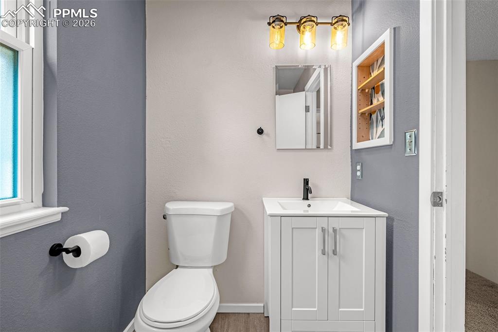 Image 19 of 41: Bathroom with a white vanity featuring a rectangular sink, matte black fauc