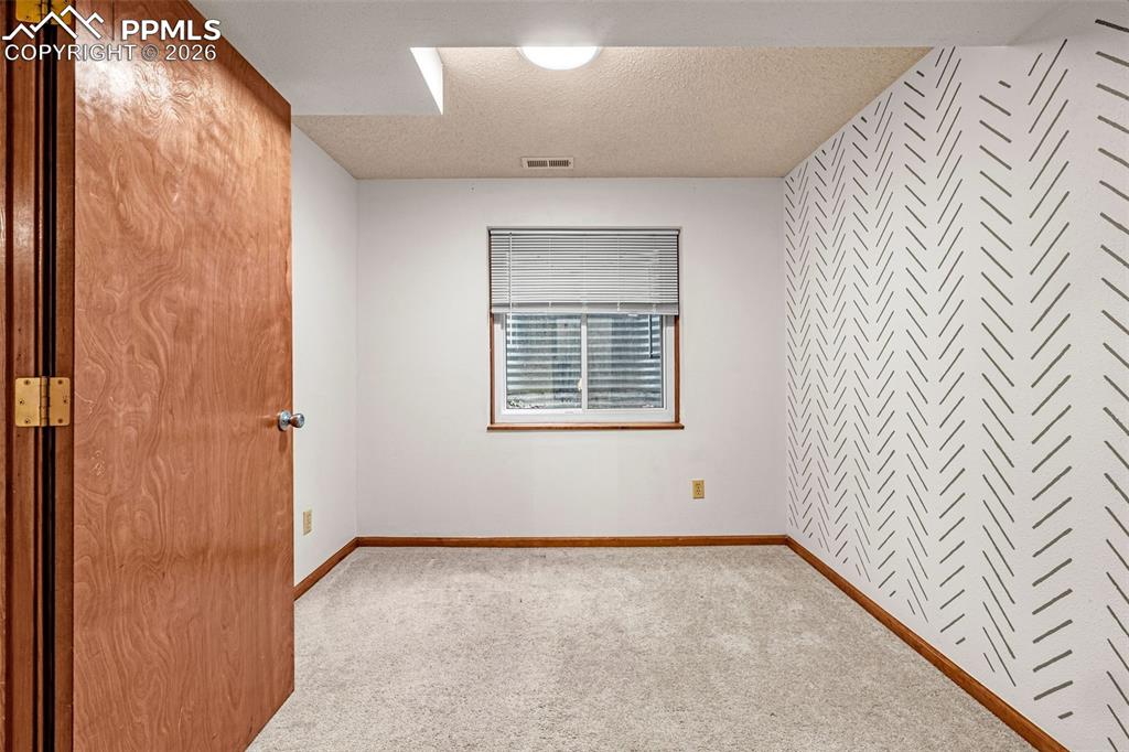 Image 22 of 41: Neutral tone wall with a patterned accent wall featuring a chevron design