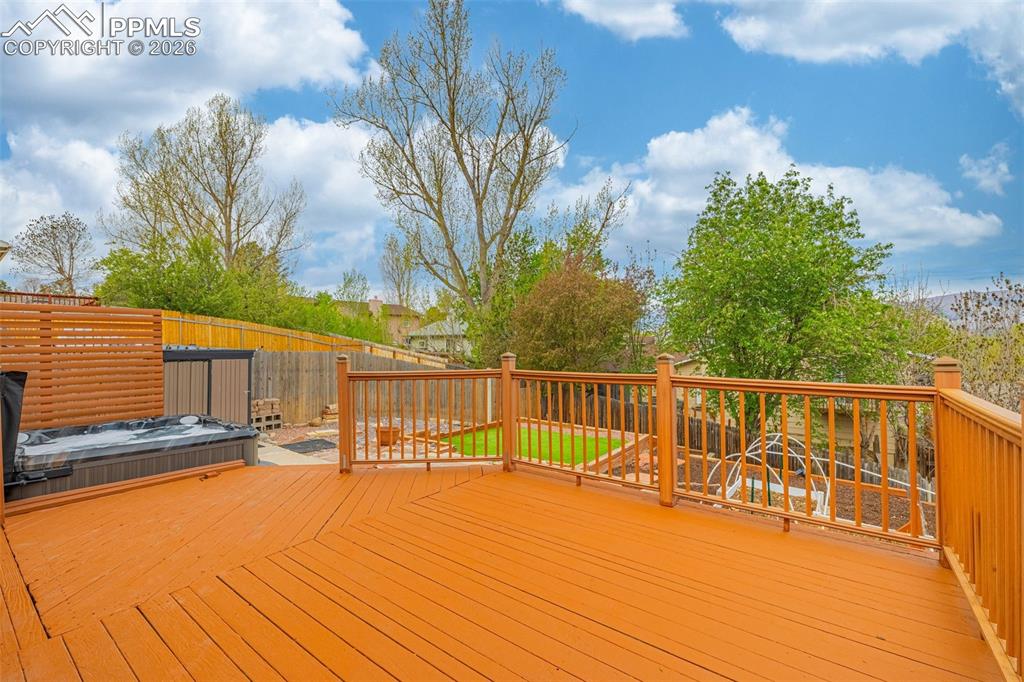 Image 25 of 41: Expansive wooden deck with a built-in hot tub