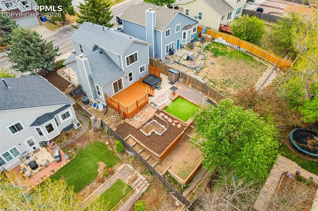 Image 33 of 41: Rear exterior featuring a multi-level wood deck, stone patio, artificial tu