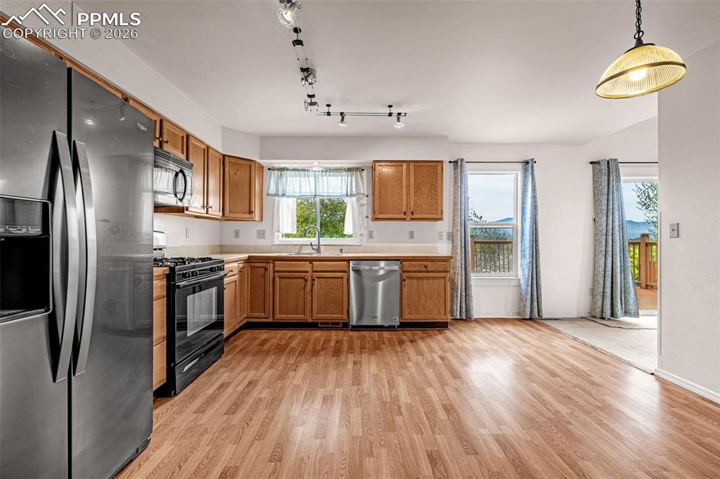 Image 9 of 41: Kitchen featuring wood-finish flooring, light wood cabinetry, white counter
