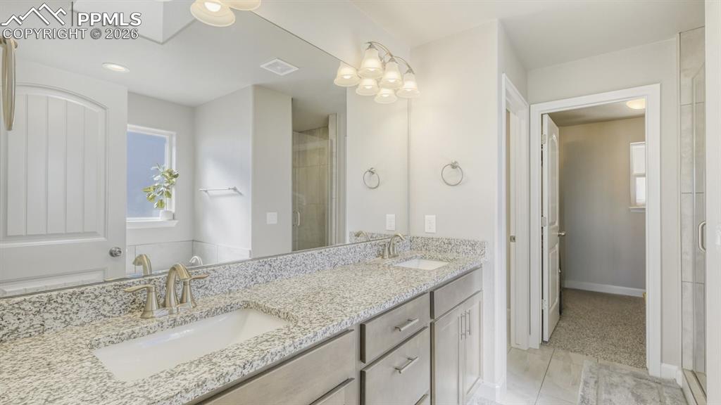 Image 20 of 42: double vanity in primary bathroom with walk-in closet