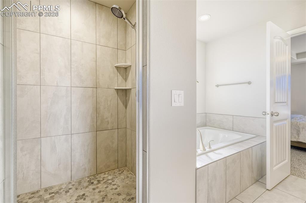 Image 22 of 42: primary bathroom tub and stand-alone shower