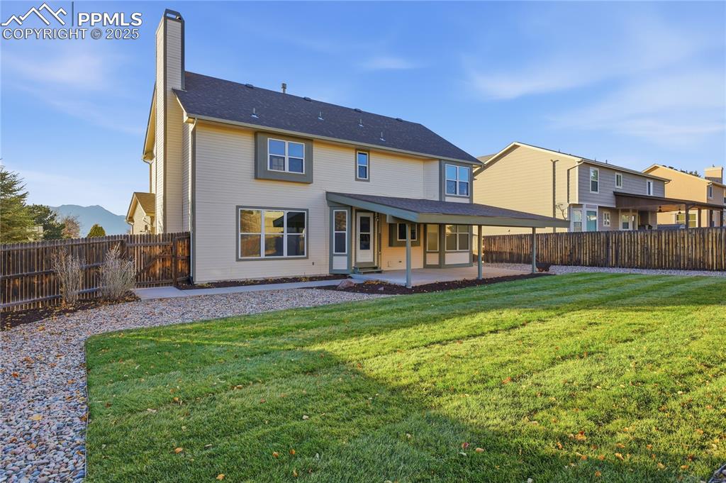Image 3 of 42: Back of house with a patio area, a chimney, and a fenced backyard