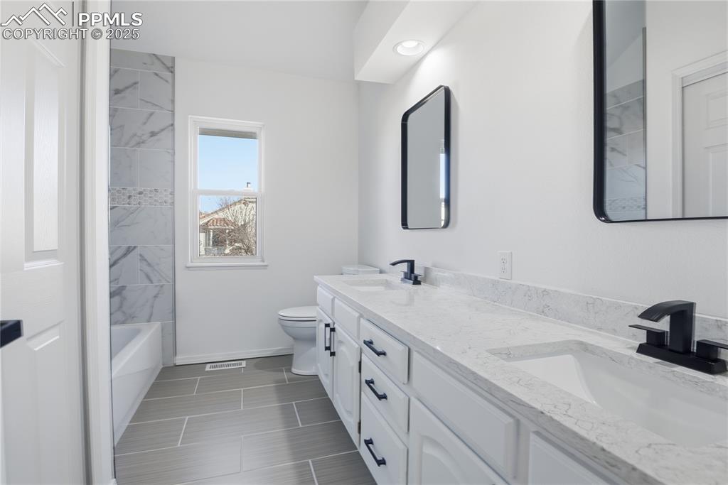 Image 30 of 42: Full bath featuring double vanity and tub / shower combination