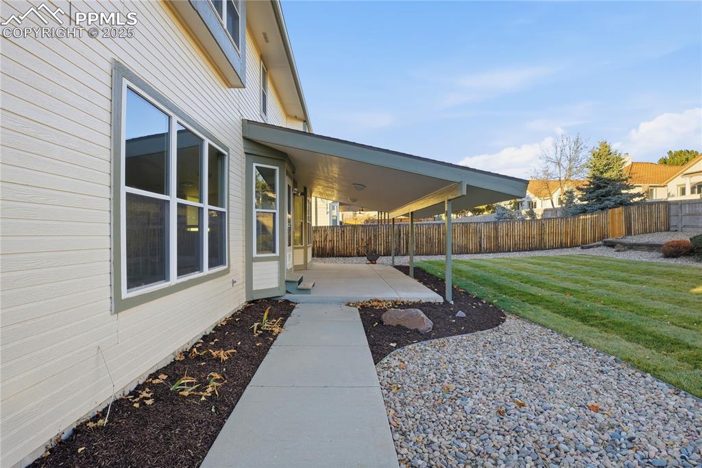 Image 36 of 42: Fenced backyard with a patio