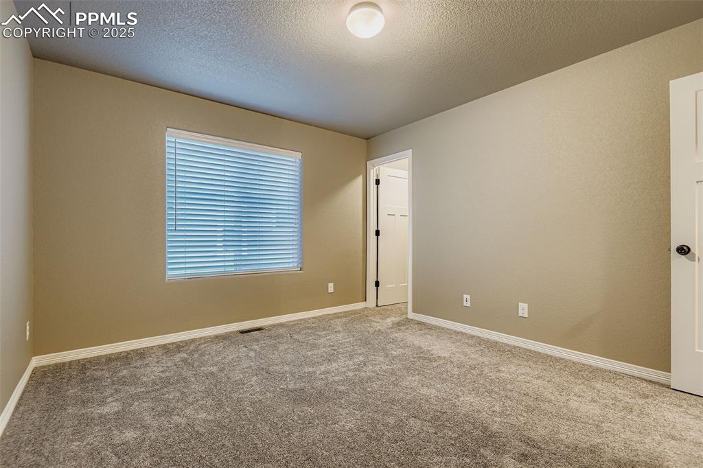 Image 18 of 28: Spare room with carpet floors and a textured ceiling