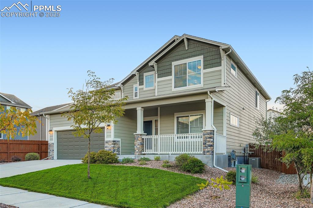 Image 2 of 28: Craftsman house featuring stone siding, a porch, driveway, and a garage