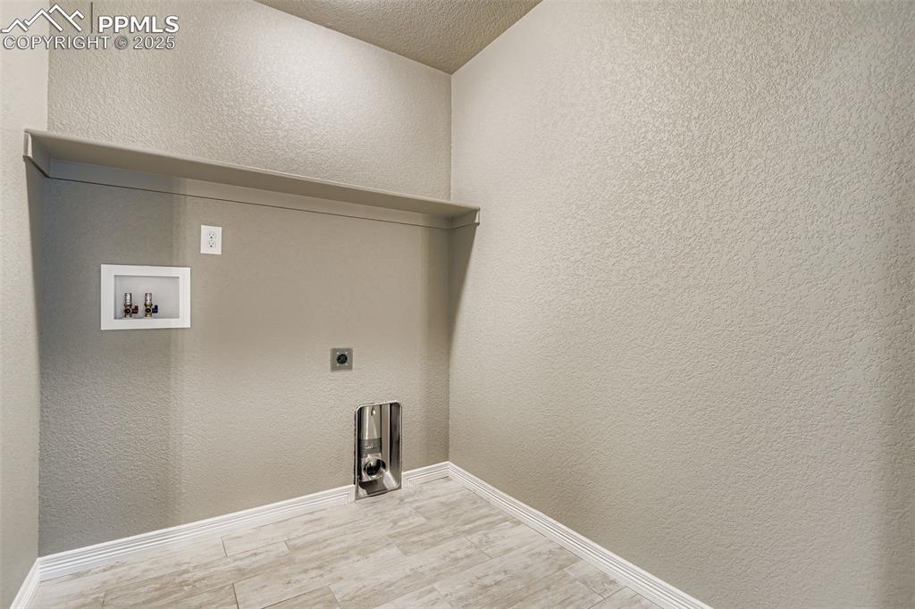 Image 21 of 28: Laundry room with a textured wall, electric dryer hookup, washer hookup, an