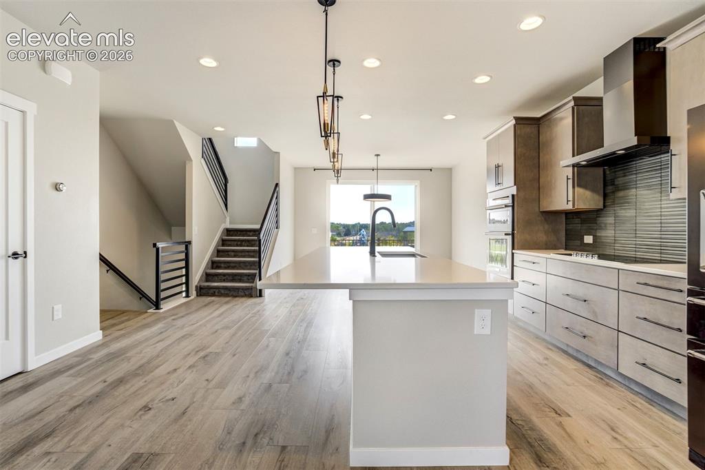 Image 11 of 50: Door to the pantry on the left and island seating, soft close drawers and c