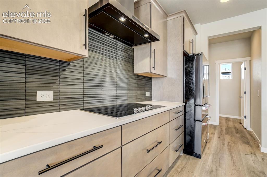 Image 16 of 50: Beautiful flat panel cabinets and back splash! Hallway leads to convenient 