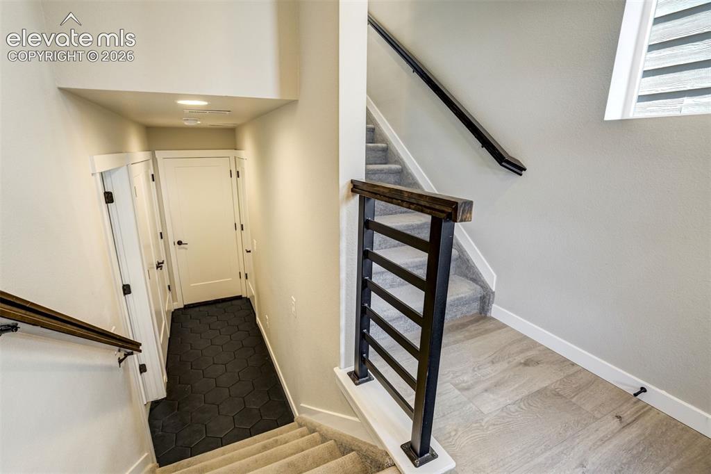 Image 40 of 50: Stairs up to the kitchen and down to the garage entrance and extra bedroom/
