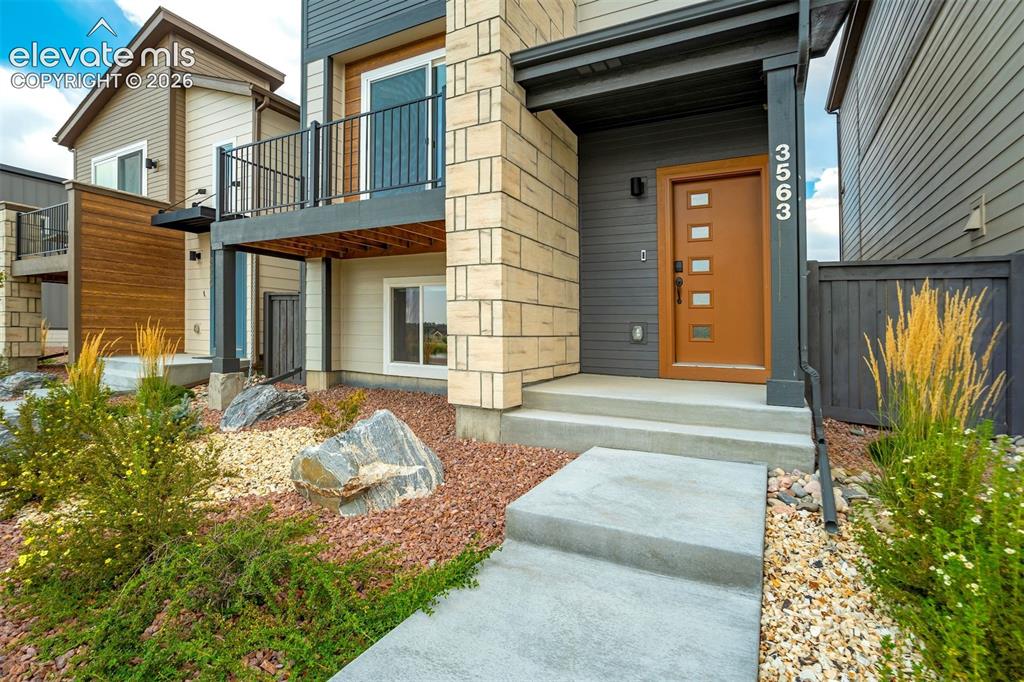 Image 7 of 50: Walkway to the front door with xeriscape design.  