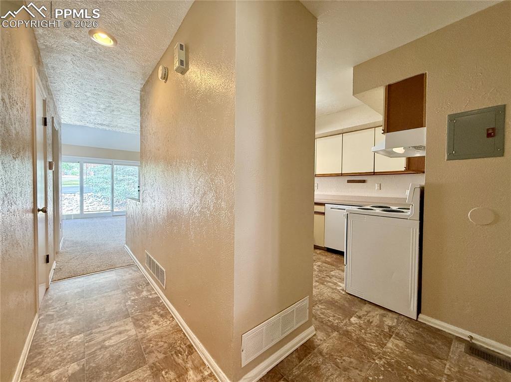Image 4 of 18: View from the front door into the kitchen and living room
