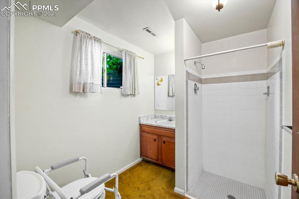 Image 28 of 38: Bathroom with vanity and a stall shower