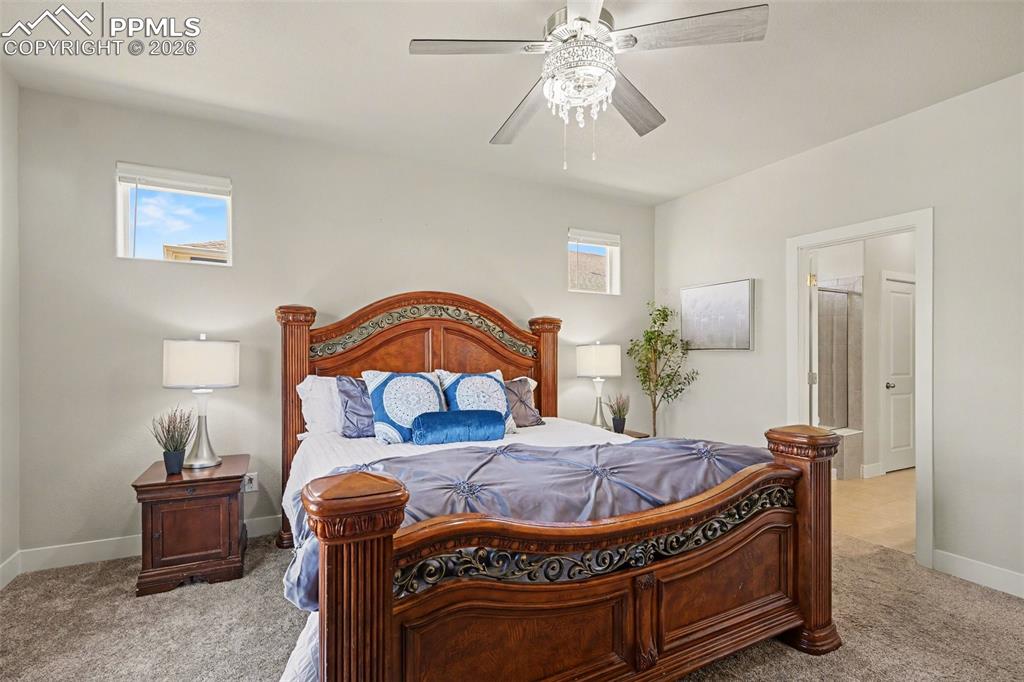 Image 15 of 37: The main-level primary bedroom is complemented by an adjoining bathroom tha