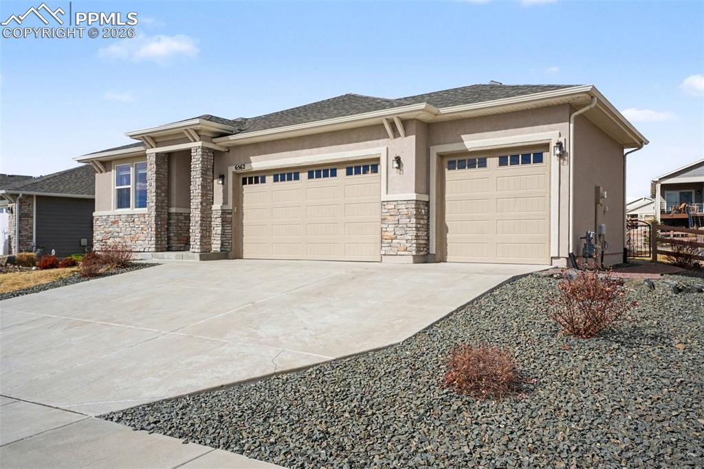 Image 3 of 37: 3-car garage with a large driveway, offering ample parking and easy access.