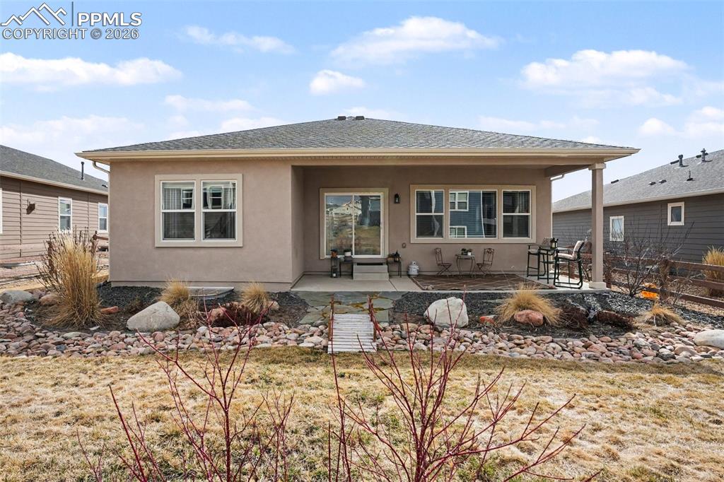 Image 35 of 37: The backyard includes a covered patio, providing a shaded area for relaxing