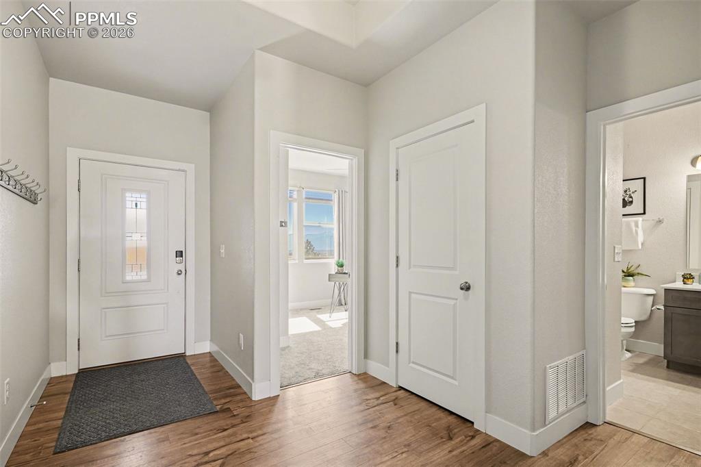 Image 5 of 37: The entry sets the tone for the home, featuring engineered flooring and sea