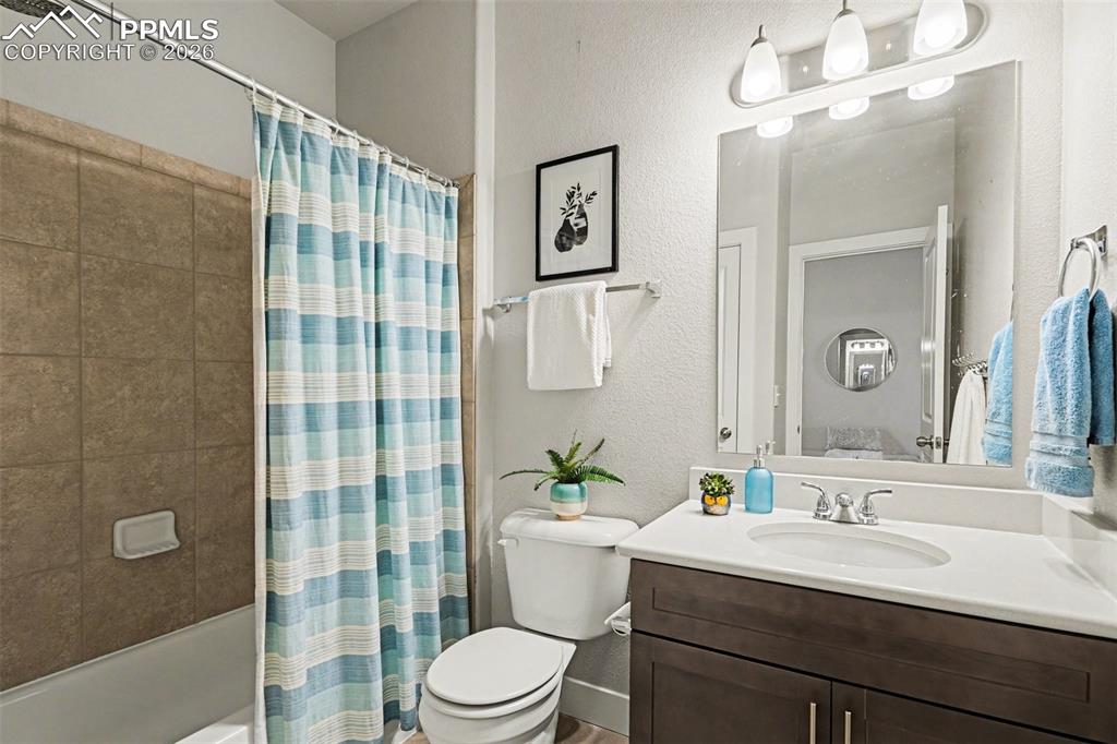 Image 8 of 37: The main-level full bathroom offers a clean, well-appointed space with a fu