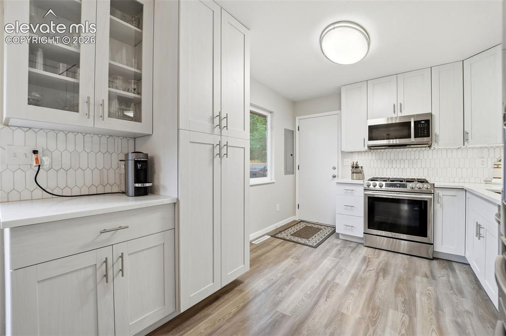 Image 12 of 38: Contemporary kitchen with light-toned wood-finish flooring