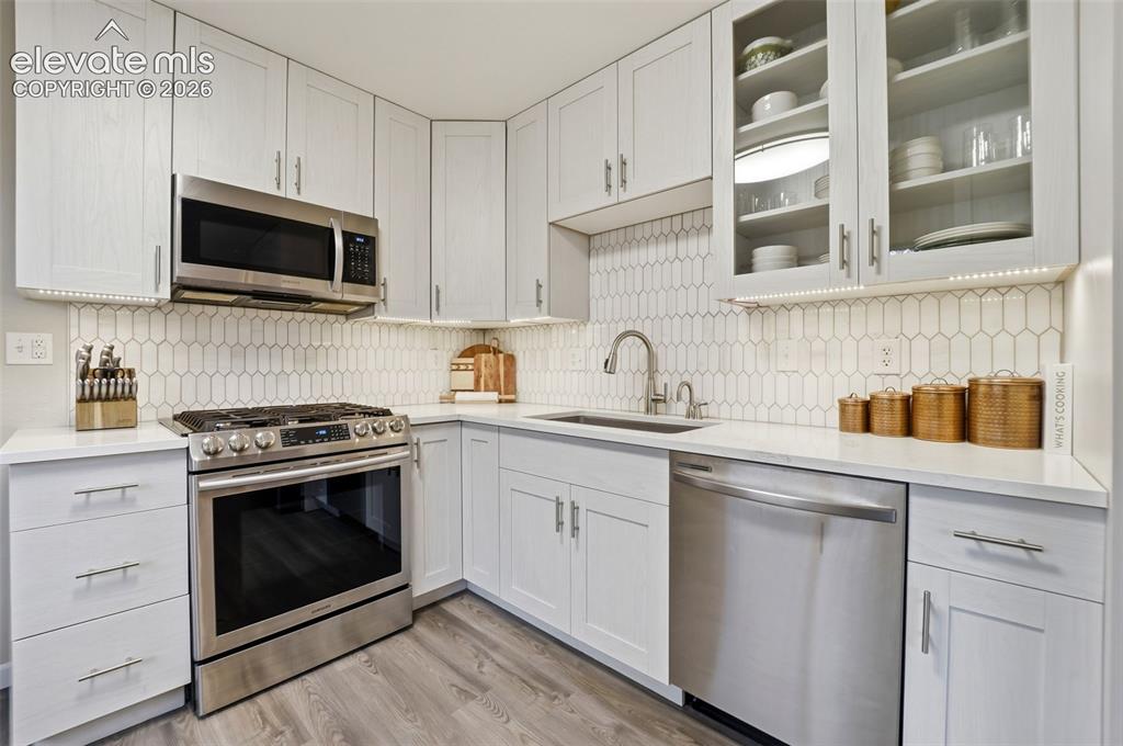 Image 13 of 38: Kitchen featuring light wood-finish flooring, white shaker-style cabinetry