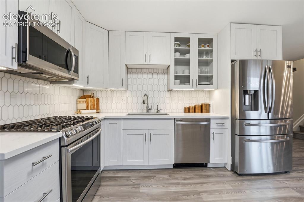 Image 14 of 38: Modern kitchen featuring light wood-finish cabinetry, stainless steel appli