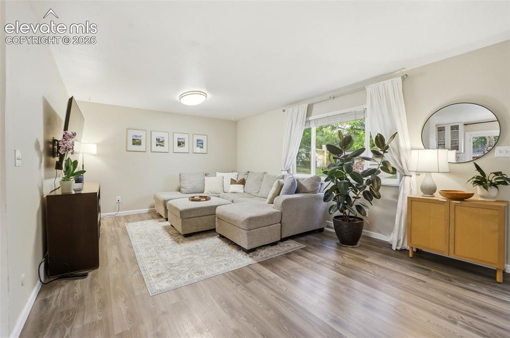 Image 17 of 38: Living area featuring wood-finish flooring, ample natural light from a larg