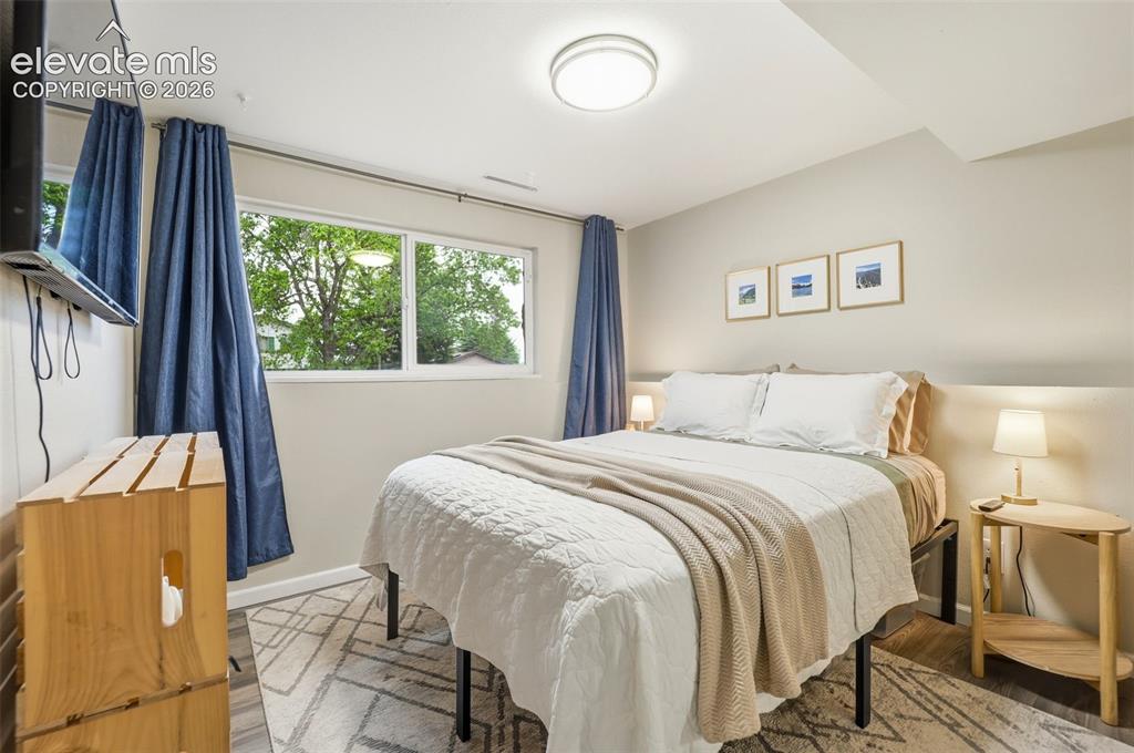 Image 18 of 38: Bedroom featuring wood-finish flooring, a broad window, and a ceiling-mount