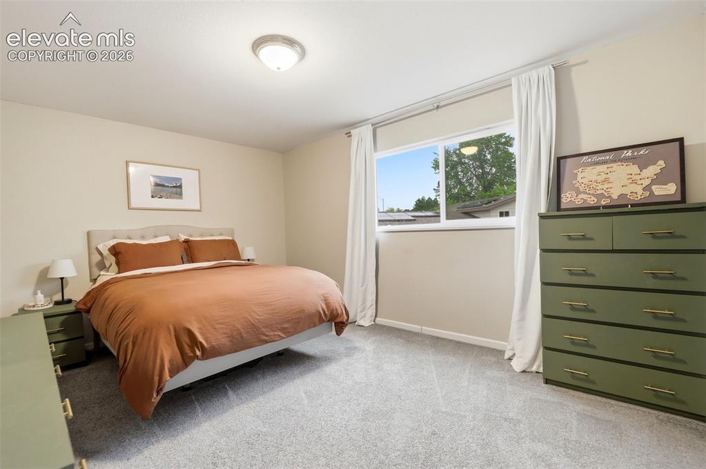 Image 28 of 38: Carpeted bedroom with neutral wall tones and a ceiling-mounted light fixtur