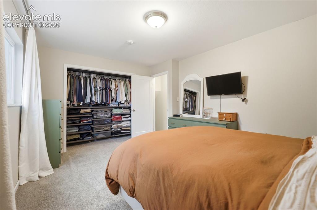 Image 30 of 38: Carpeted room featuring a built-in closet organization system, recessed win