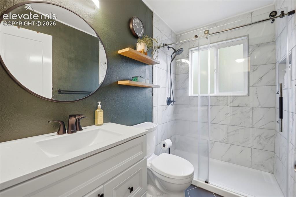 Image 34 of 38: Bathroom featuring a white vanity with integrated sink, dark bronze-finish