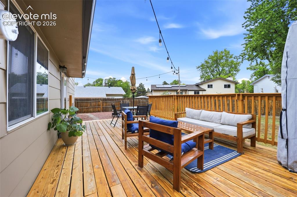 Image 35 of 38: Expansive wooden deck with a natural finish, featuring string lighting and