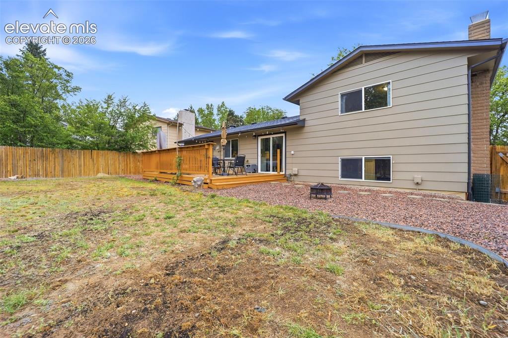 Image 37 of 38: Expansive backyard featuring a wood privacy fence, a multi-tiered wood deck