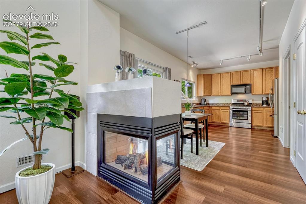 Image 16 of 50: Three sided fireplace between living room anddining room