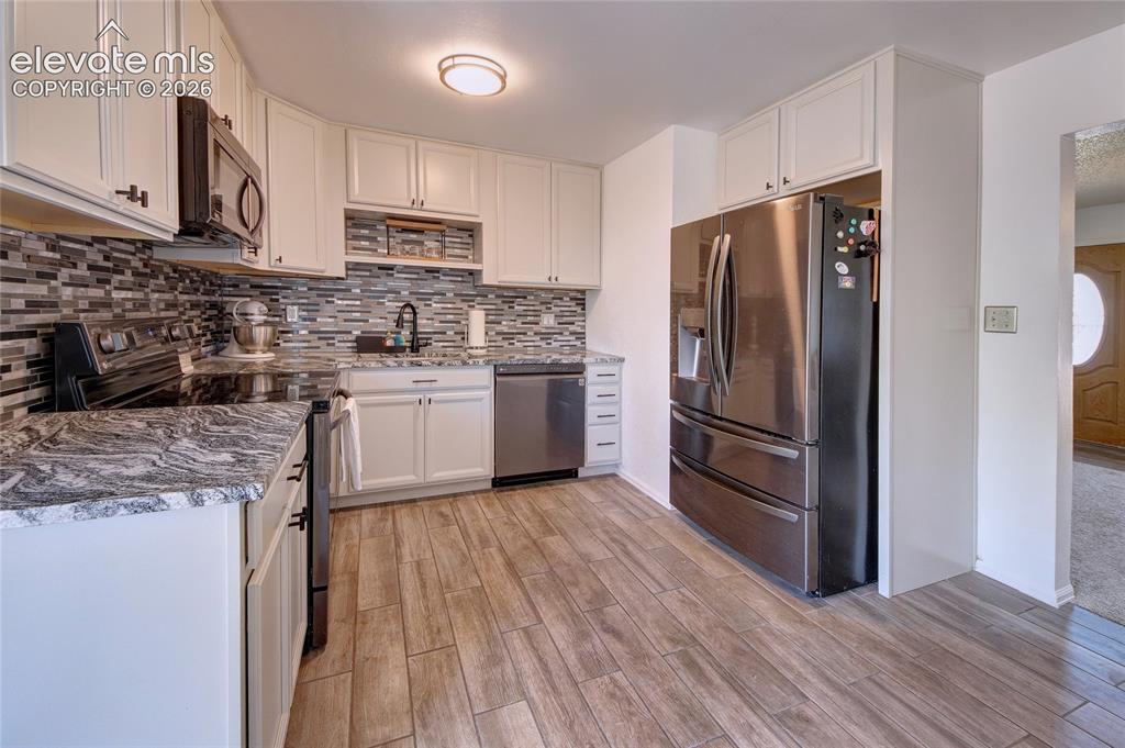 Image 2 of 26: Kitchen showcasing granite tops and back splash