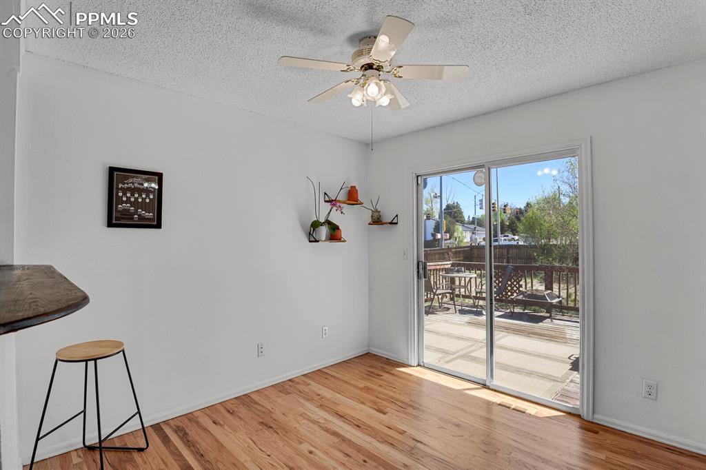 Image 10 of 30: Living area featuring hardwood floors, a ceiling fan, and a sliding glass d