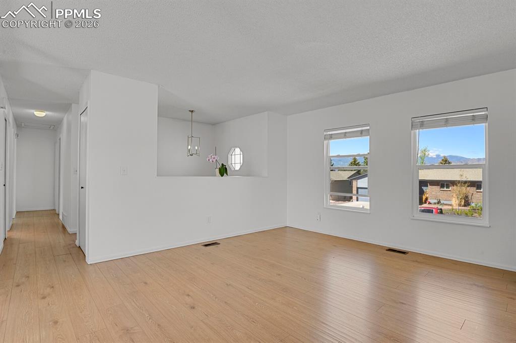 Image 11 of 30: The spacious room features light-toned flooring and white walls, offering a