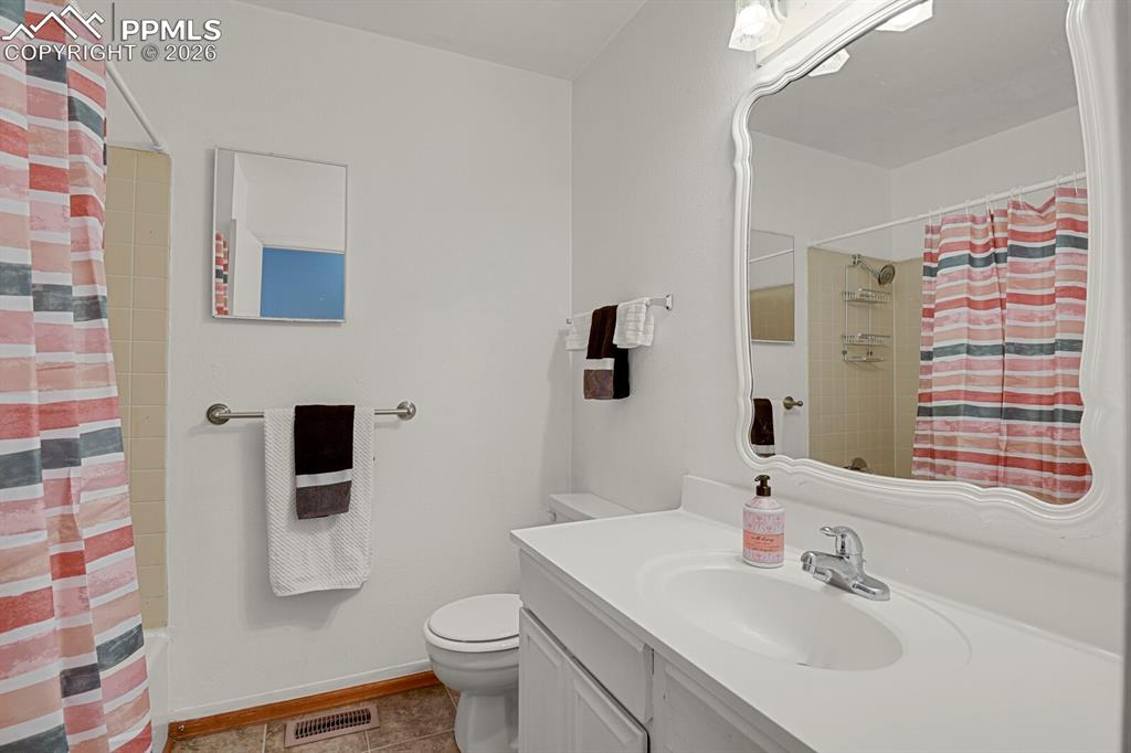 Image 13 of 30: Bathroom featuring a vanity with an integrated sink, a large decorative mir