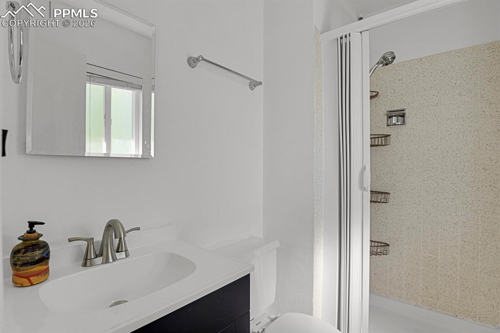 Image 17 of 30: Bathroom featuring a vanity with a white countertop and an integrated sink,