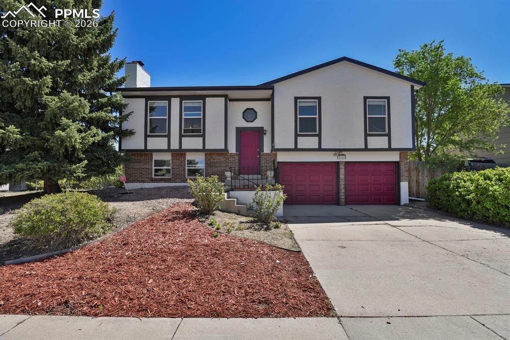 Image 2 of 30: The property features a white exterior with dark trim, a red front door, an