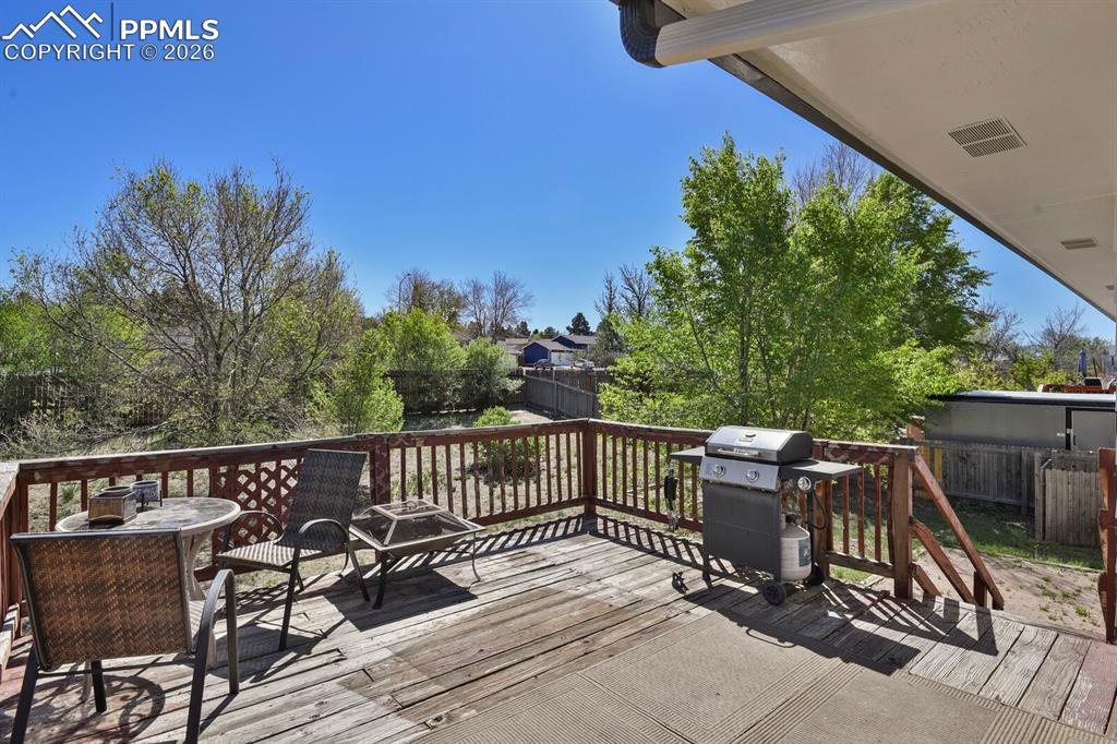 Image 25 of 30: The property features an outdoor deck with a wooden railing, offering an op