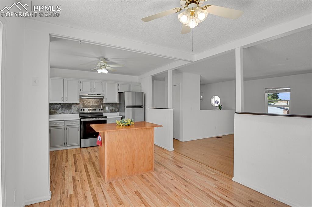 Image 5 of 30: The property features an open-concept living space with light-toned wooden 